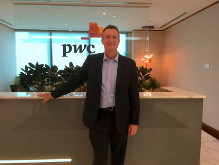 Cybersecurity in Singapore for business: A man posing for a photo at the PwC office