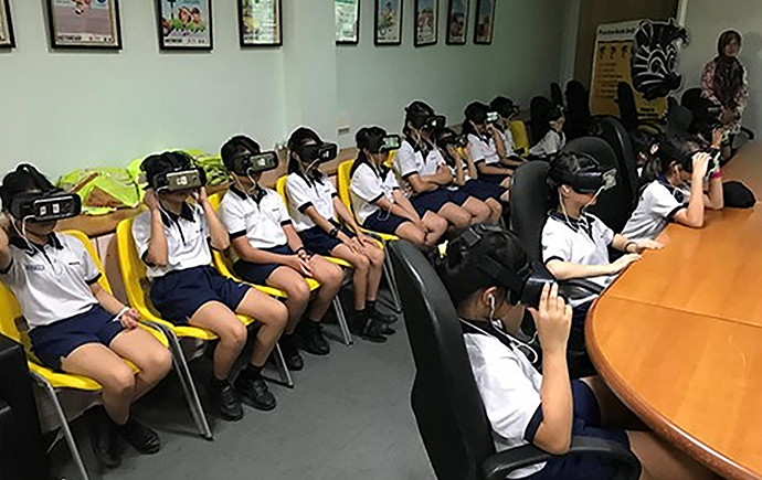 A group of students wearing VR headsets participating in VR-enabled road safety education