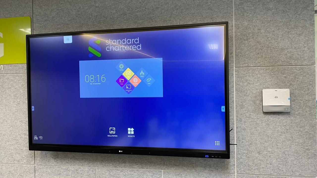 IMDA Spark Programme: TV screen on the wall and uHoo Aura indoor air quality monitoring device in a Standard Chartered Bank office