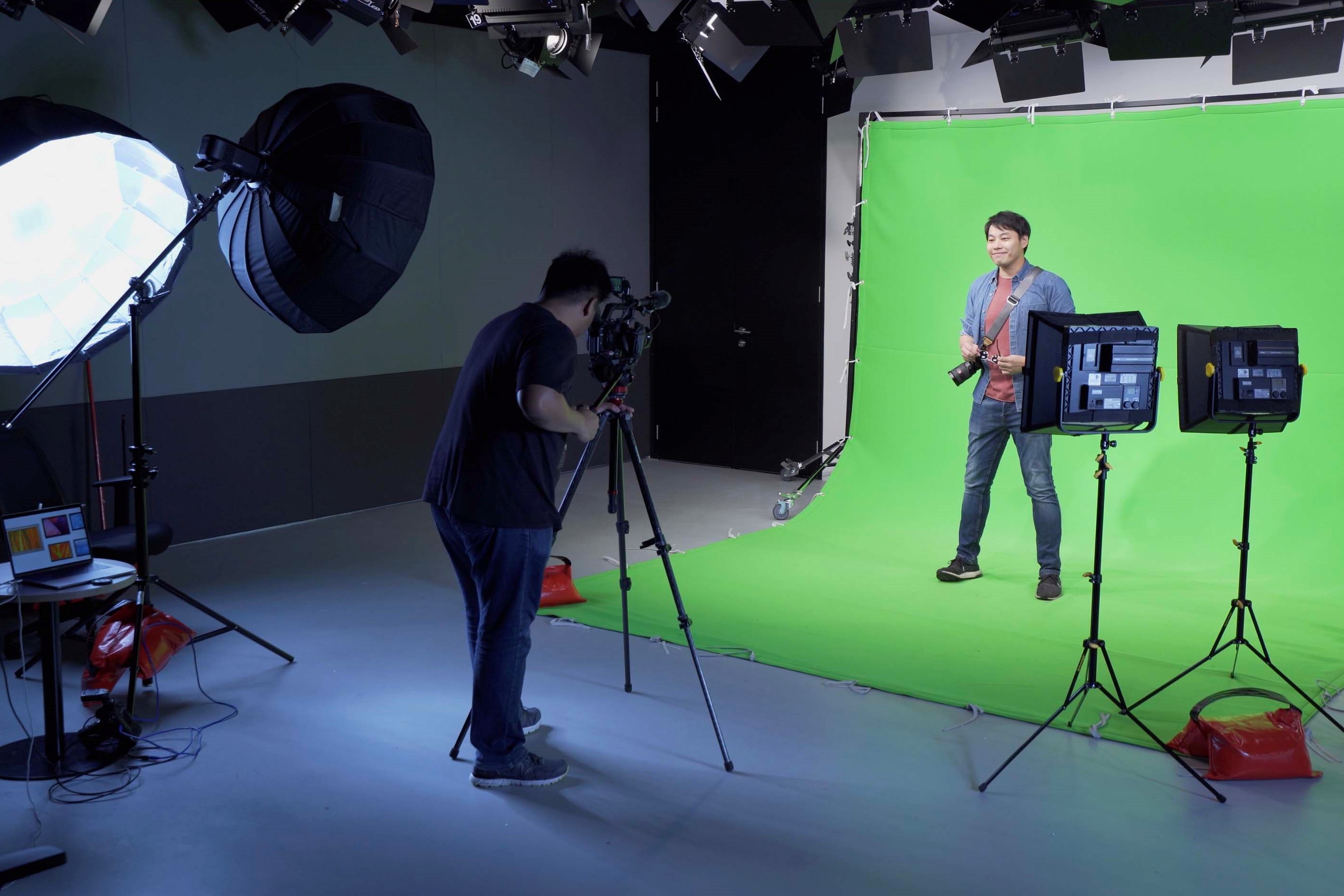 A videographer filming a man at IMDA's PIXEL studio under its production facilities