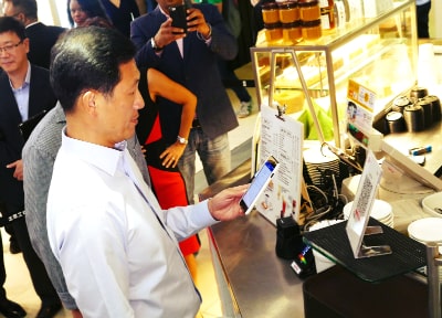 Mr Ong Ye Kung scanned an SGQR code with his smartphone to make a digital payment for a cup of coffee