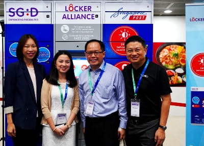 Jane Lim, IMDA's Assistant Chief Executive for Sectoral Transformation, and other representatives pose in front of a SingPost locker station