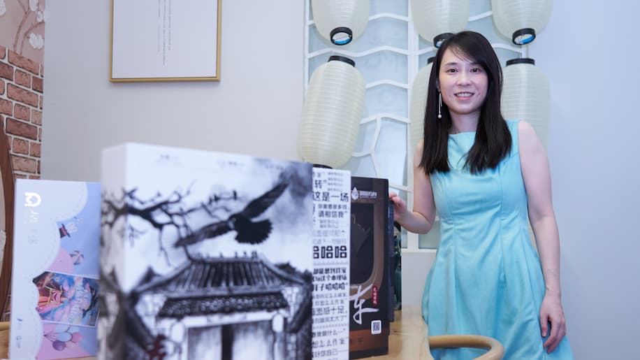 A woman standing beside boxes of games