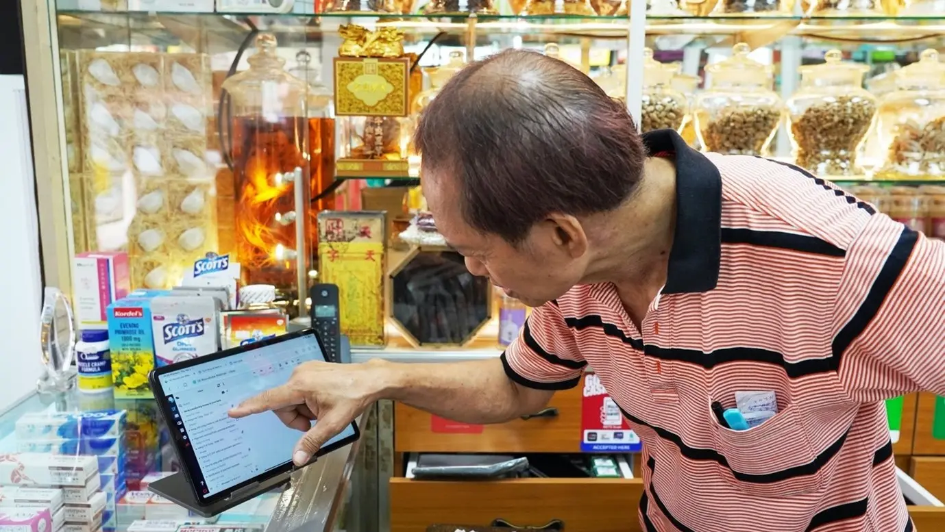 Mr Lee is using his iPad to manage Heng Foh Tong Medical Hall’s e-commerce platform with the help of IMDA's training