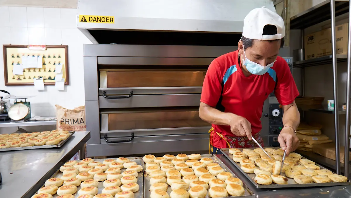 An employee at House of Tau Sar Piah flips the pastries in the kitchen