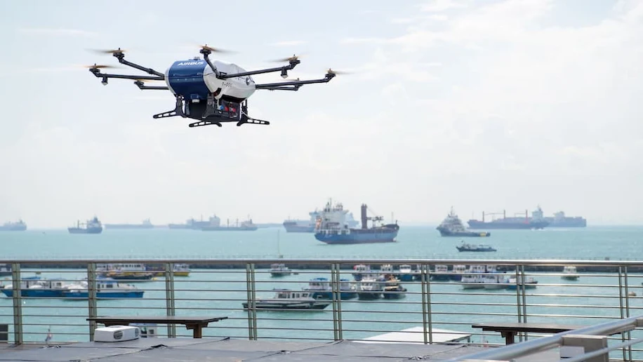 An AIRBUS drone used for maritime services, with other ships in the background. This technology is part of IMDA's 5G innovation programme.