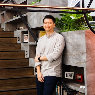Chief Product Officer and SG Digital Leader Justin Lee posing in the ShopBack office by wooden steps.