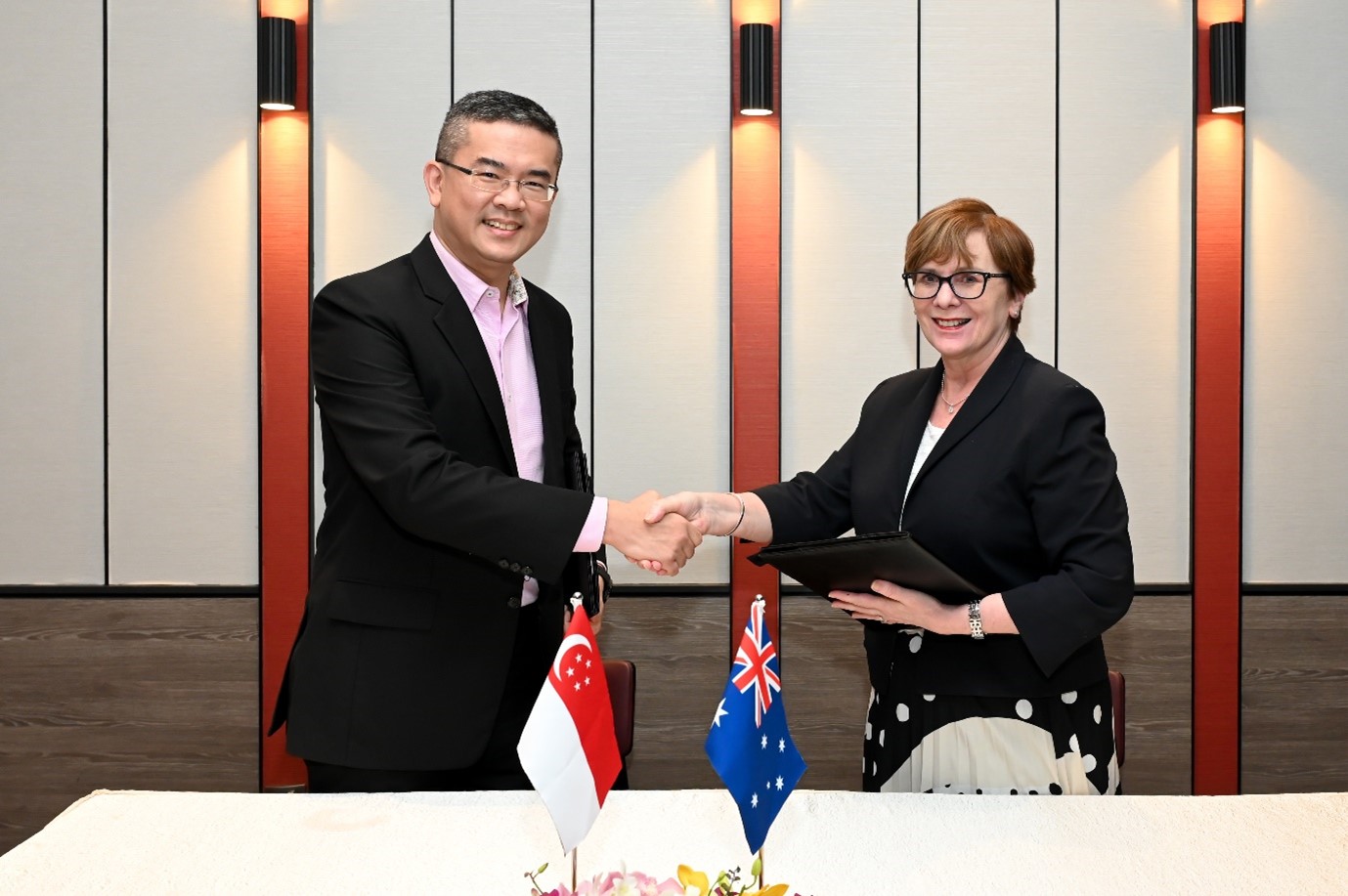 ACMA Chairman, Mrs Nerida O'Loughlin and IMDA CEO, Mr Lew Chuen Hong, shook hands after the signed MOU as part of combating online scams