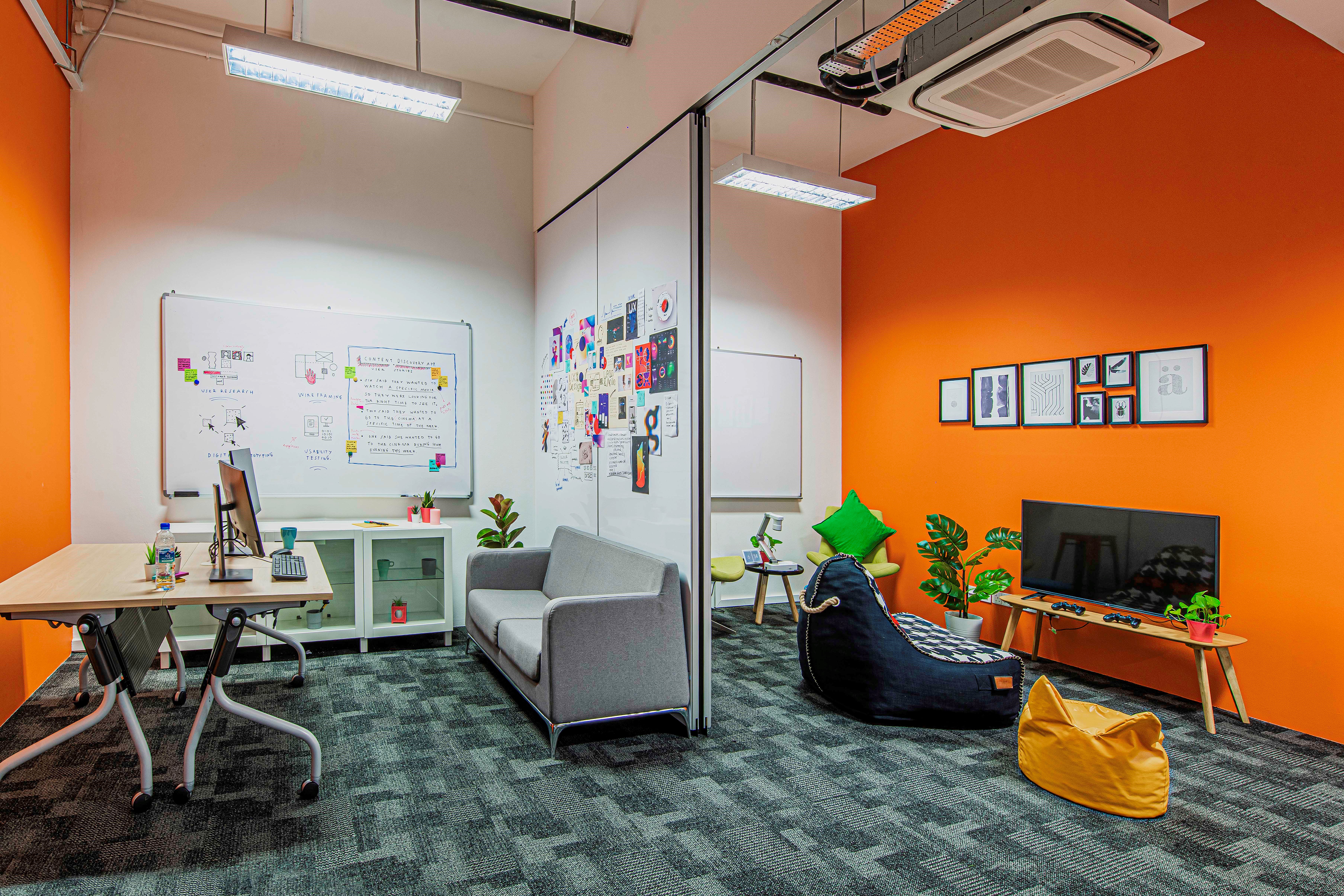 A room divider separates a space featuring whiteboards, a desk, and chairs in IMDA's PIXEL UI/UX lab