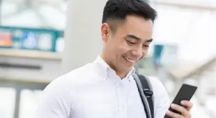 A man using his smartphone for wireless connectivity in Singapore, a key initiative in IMDA's efforts to promote digital for life