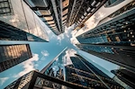Our think pieces and exclusive content " (Default Alternate Text: "Tall office buildings reaching towards the sky, possibly representing the rapid development of Singapore's SMEs go digital program and 5G