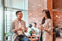 Learn more about IMDA’s career opportunities and join us as Architects of Singapore’s Digital Future" (Default Alternate Text: "Two professionals engaged in discussion over coffee, emphasising the significance of building networks and collaborations
