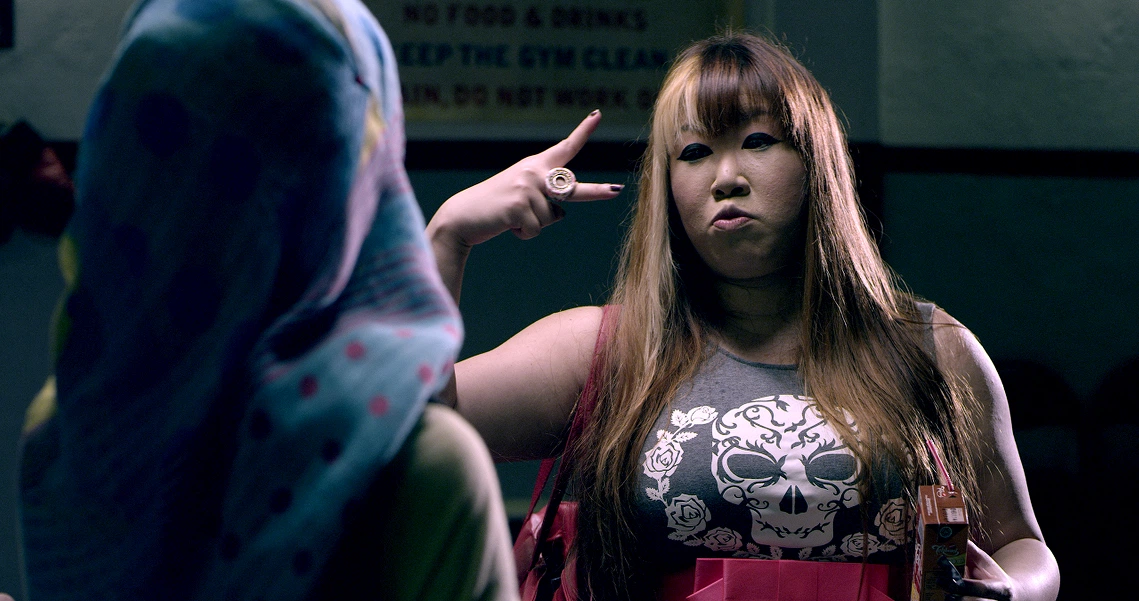 A tense scene from the film Banting shows a woman in a skull-print shirt gesturing at another person in a hijab.