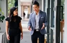 Two business professionals walk and chat