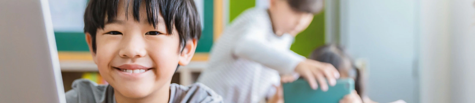 Asian boy using computer to learn lessons in elementary school student boy studying
