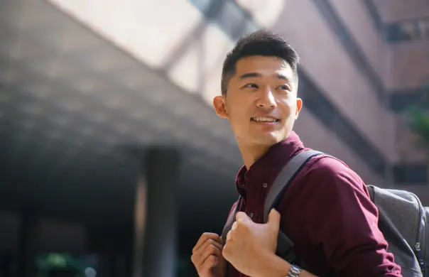 Male student with backpack on his way to school, attending IMDA's SG digital scholarship or IT courses in Singapore