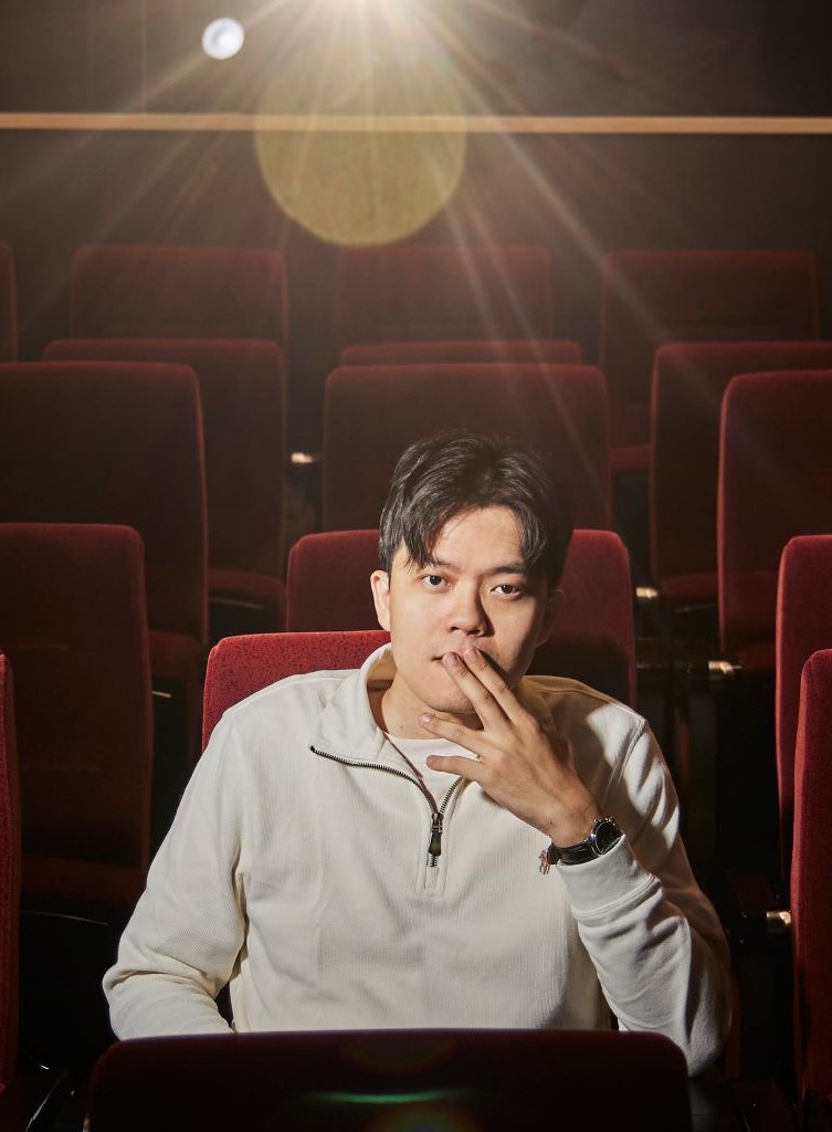Image alt text: A man sitting in the theatre.