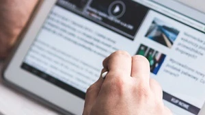 A man scrolling on his tablet with his stylus, possibly reviewing data-sharing policies