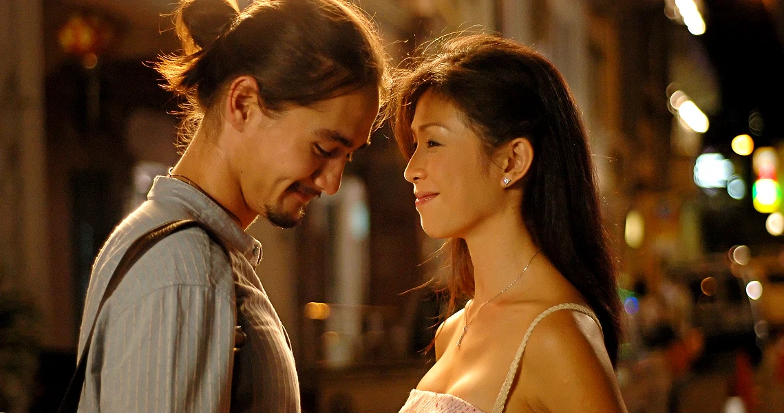 A romantic scene from "The Leap Years" shows a couple gazing at each other intimately on a warmly lit street at night.